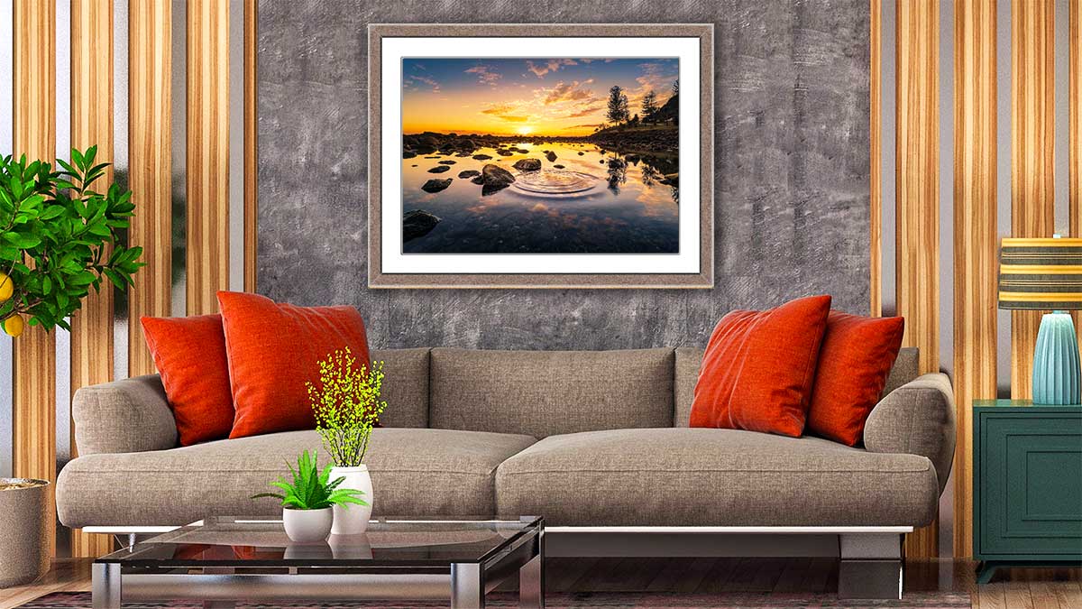 A1 frame with a picture of a sunset reflecting in a pool of water, the frame perfectly matching the sofa beneath