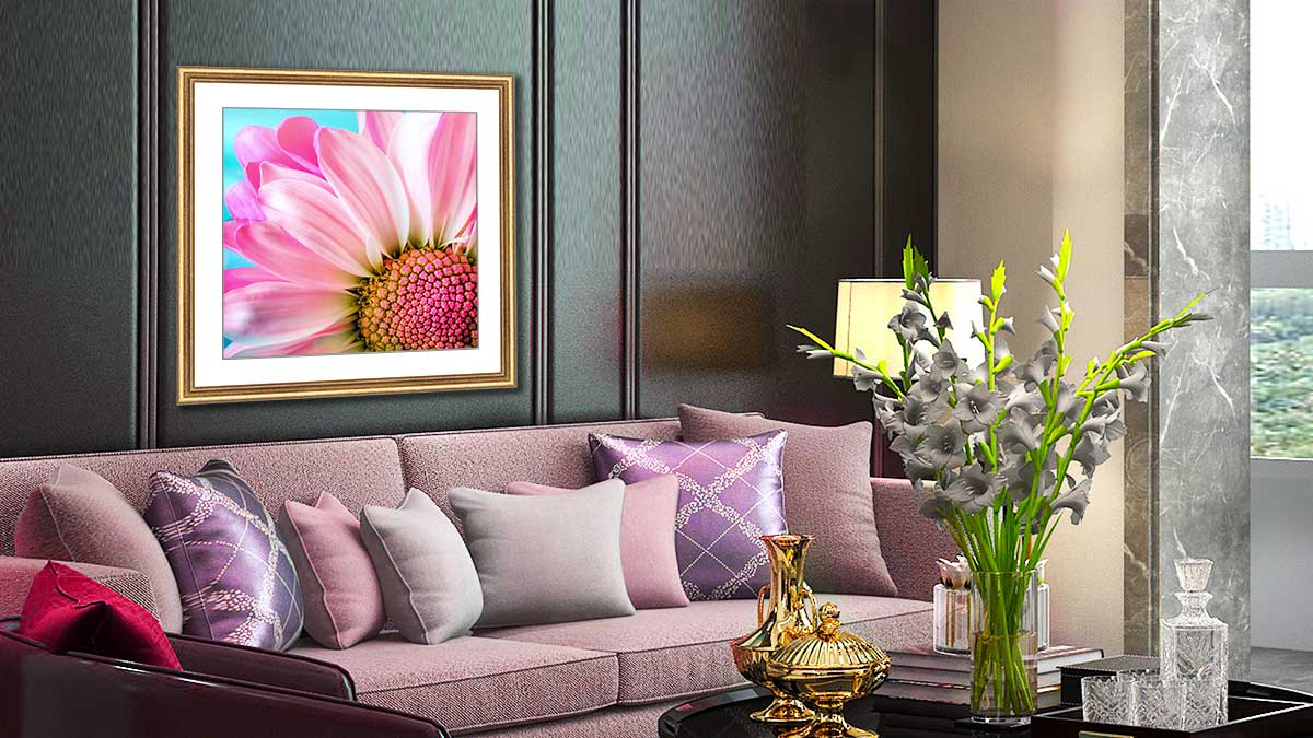 Dazzling photo of a pink flower in a gold frame hanging above a pink settee