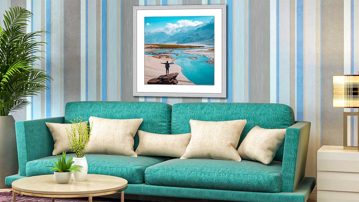 Dramatic landscape landscape photography of clouds over an aquamarine river estuary, framed and displayed over an aquamarine settee