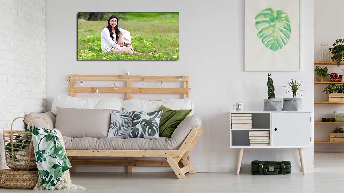 Panoramic print of a young lady sitting in a meadow hanging in a sitting room