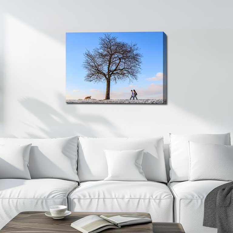Canvas print of a couple walking their dog in the snow in a sitting room