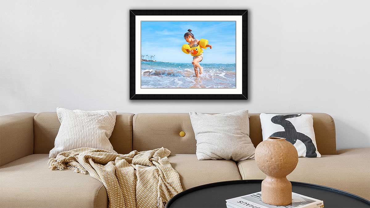 A1 frame with a picture of a child playing in the water at the seaside wearing bright yellow armbands.