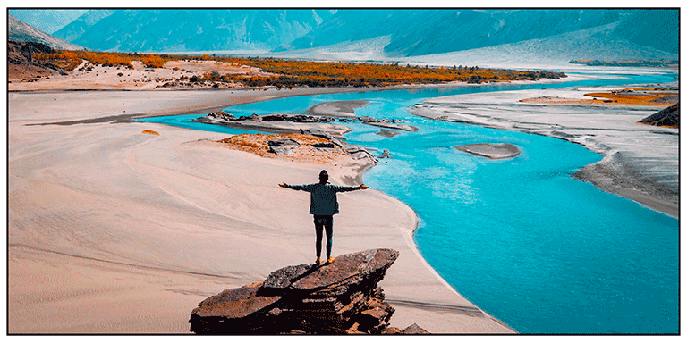 Poster print of a man standing on a rock in a river estuary