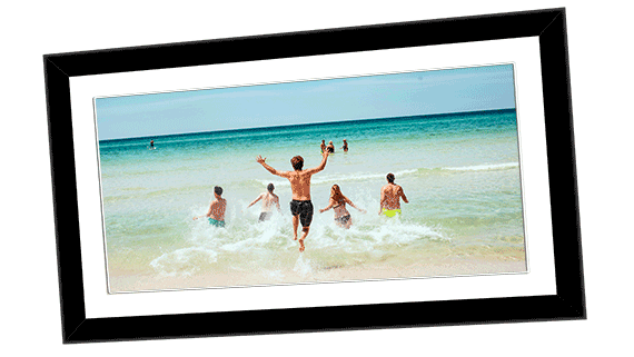 Framed poster of a panoramic photo of a group of young adults running into an aquamarine sea