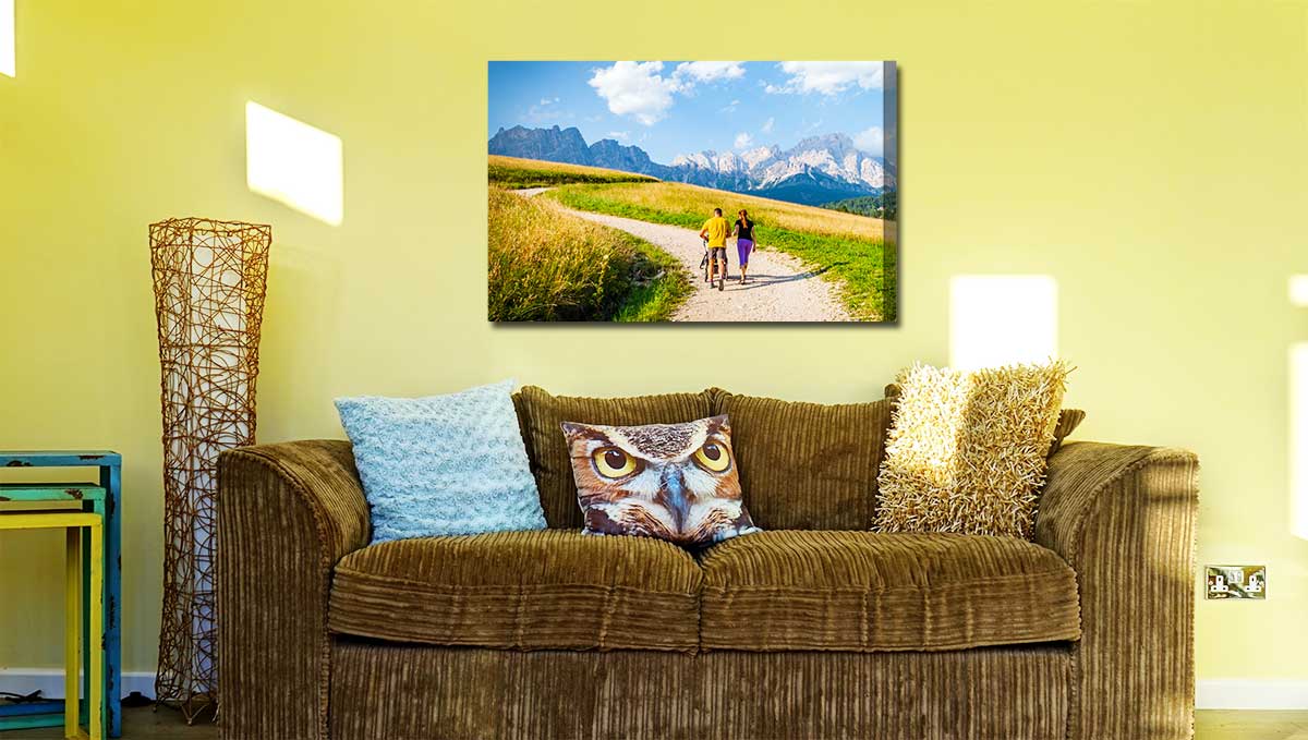 Canvas print depicting a couple walking along a hilly trail whilst pushing a pram