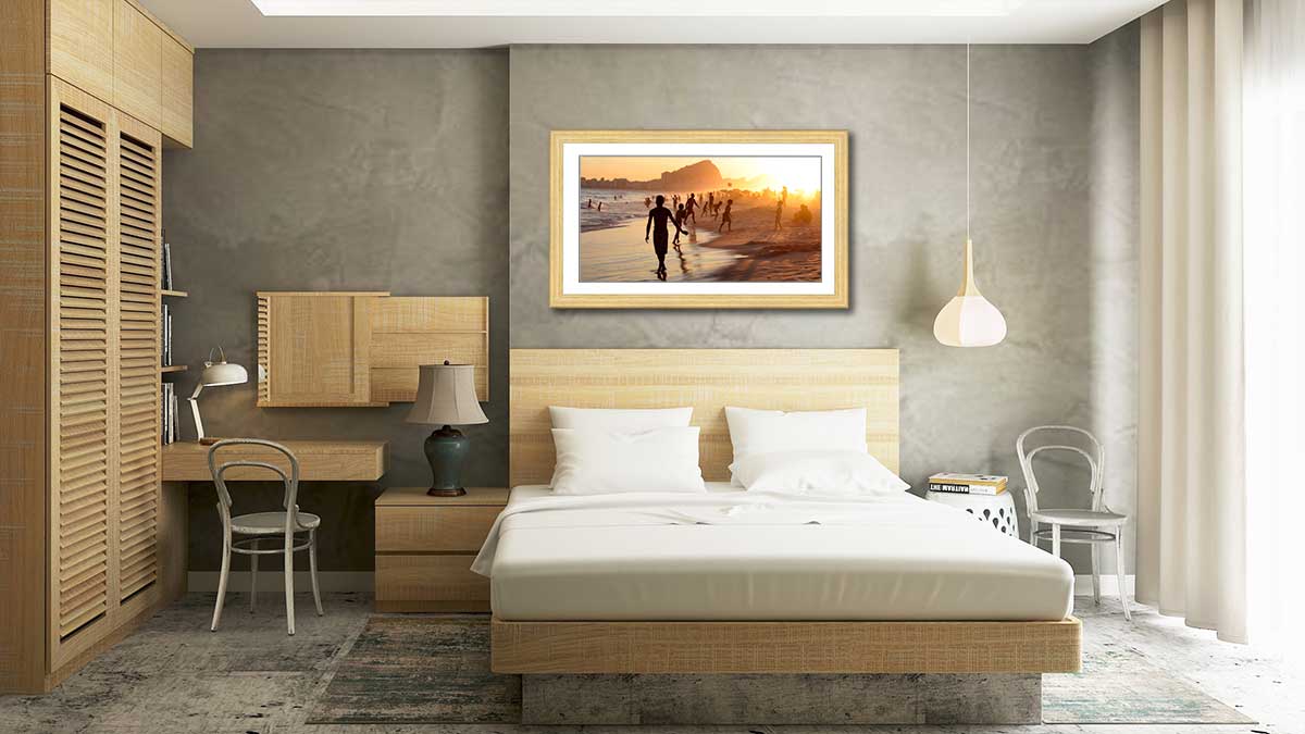 Panoramic picture of a beautiful tropical beach sunset framed in natural wood over a wooden bedstead.